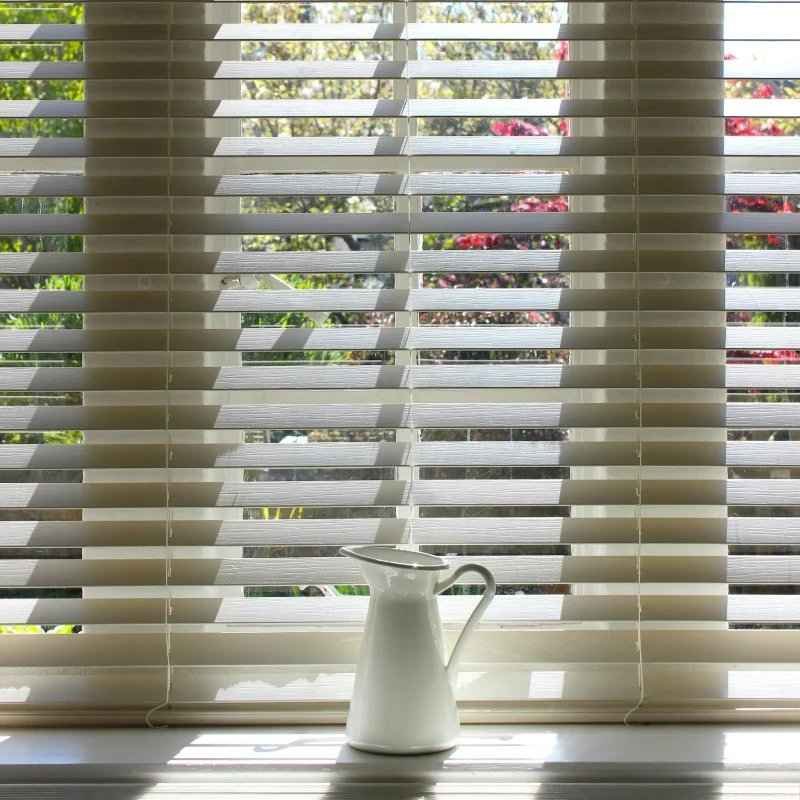 Bright window with white horizontal blinds