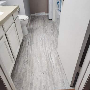 Grey LVP floors in a McFarland, WI bathroom by Bisbee's Flooring Center